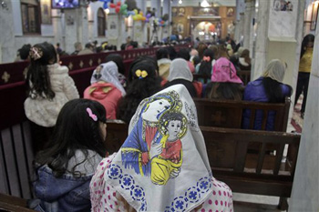 Worshippers attend Orthodox Christmas Eve Mass, where an Oct. 2013 deadly drive-by-shooting killed several at a wedding party, in the Warraq neighborhood of Cairo, Egypt late Monday, Jan. 6, 2014.