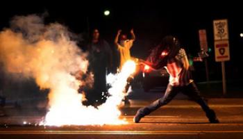 Protests in the St. Louis suburb as the result of a white police officer shooting and killing an unarmed black teenager to death turned violent Wednesday night, with people lobbing Molotov cocktails at police who responded with smoke bombs and tear gas to disperse the crowd.
