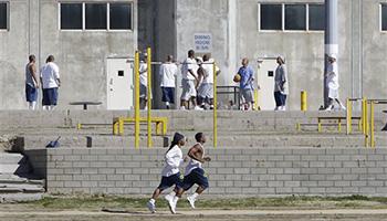 In this 2013 file photo, inmates work out in the exercise yard of Housing Unit B at California State Prison Sacramento, near Folsom, Calif. California prison officials on Wednesday Oct. 22, 2014, agreed to end a policy in which it segregated prison inmates after riots based on their race as a way to prevent further violence.