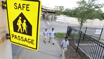 School Children walk a safe passage route along 63rd Street on the opening day of school this week, in Chicago. Chicago children returned to school walking past even more guards than last year, when concerns about safety prompted the city to line the streets with 1,200 adults every day.