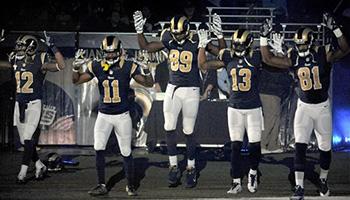 Members of the St. Louis Rams raise their arms in awareness of the events in Ferguson, Mo., as they walk onto the field during introductions before an NFL football game against the Oakland Raiders, Sunday, Nov. 30, 2014, in St. Louis. The players said after the game, they raised their arms in a "hands up" gesture to acknowledge the events in Ferguson.