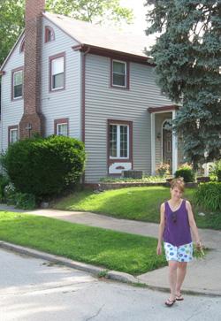 Christine Shunko standing in front of her home