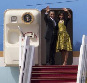Barack and Michelle Obama waving from the door of Air Force One